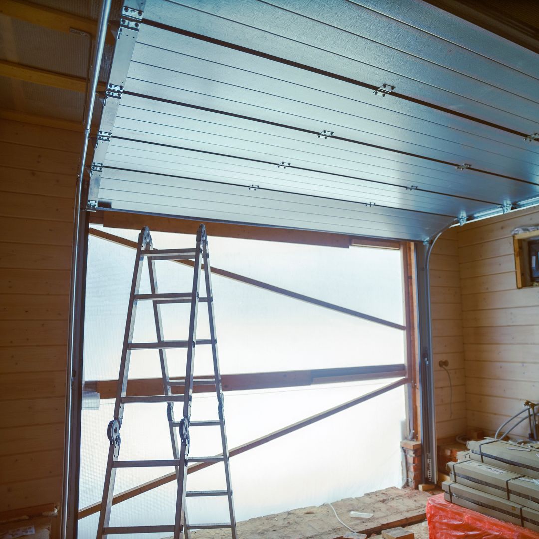 Sectional garage door being repaired inside a garage in New Braunfels, TX