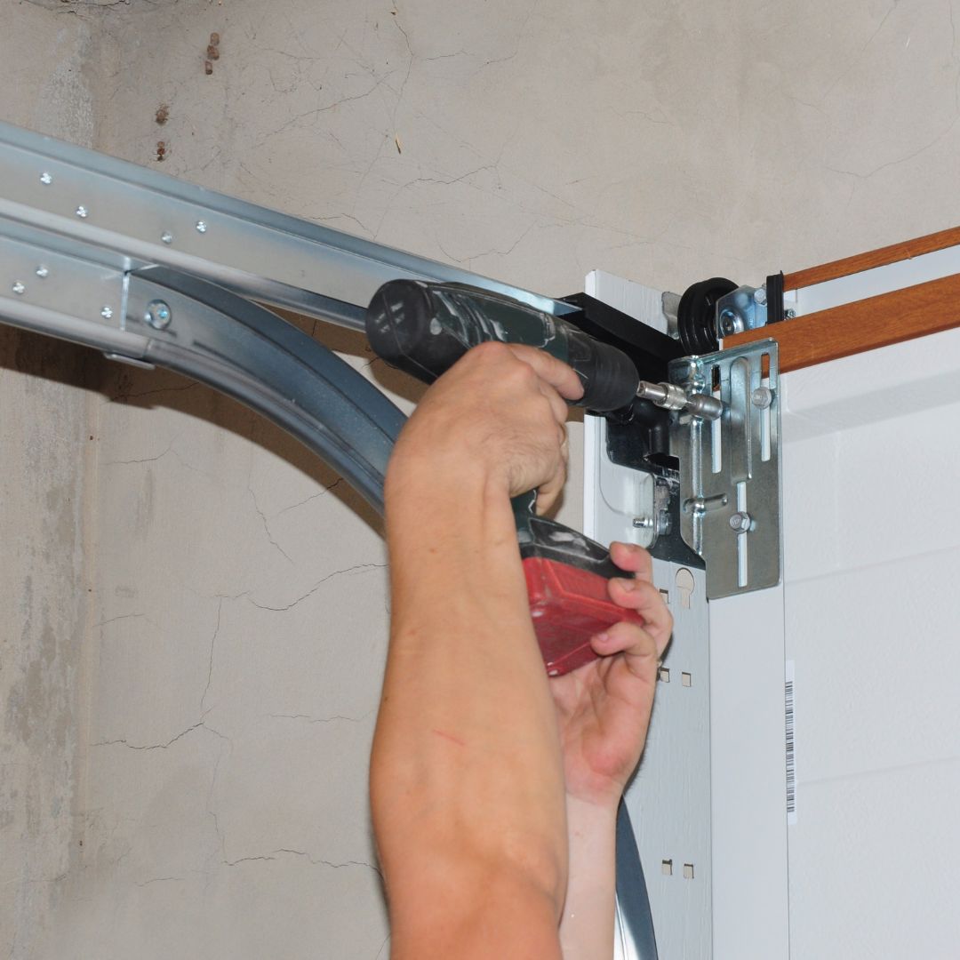 Technician tightening a garage door track bracket