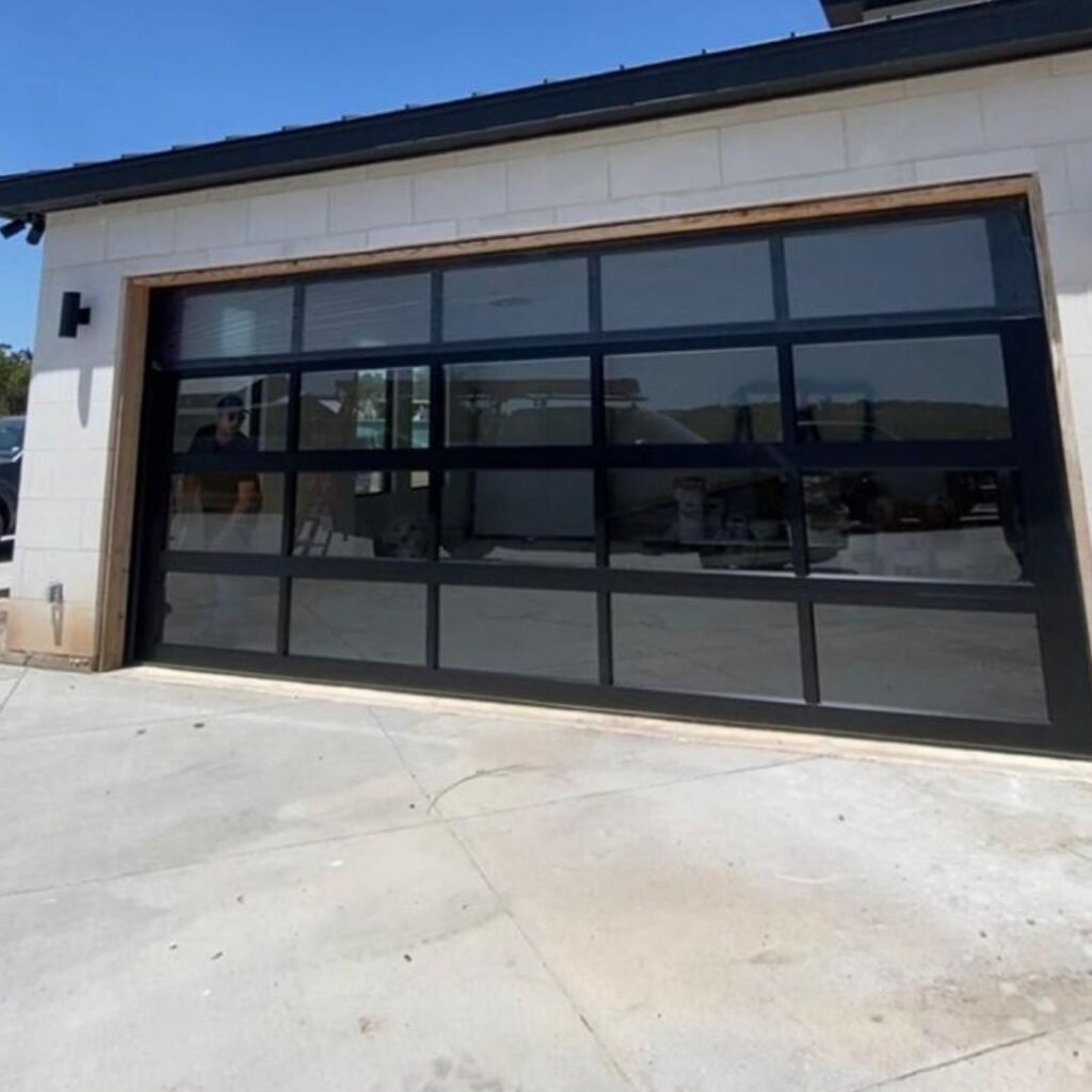 Black full-view glass garage door on a modern home