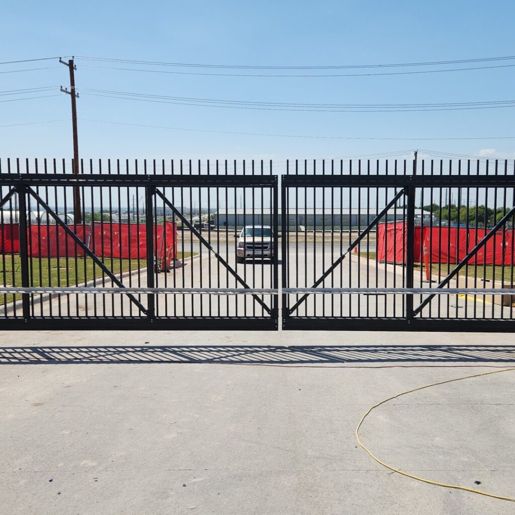 Black steel bi-parting cantilever slide gate at a commercial entrance in Buda, TX