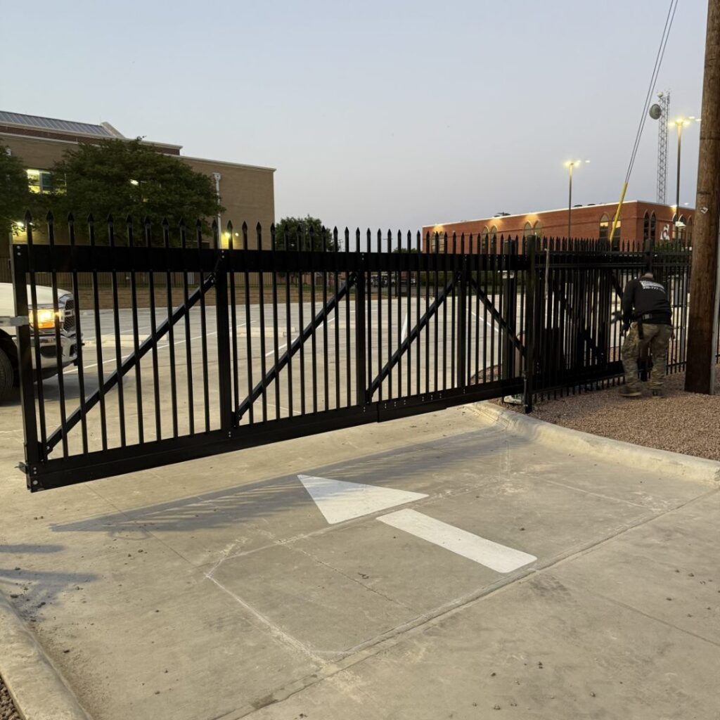 Black steel commercial cantilever slide gate installed by The Texas Garage Doors crew in Kyle, TX